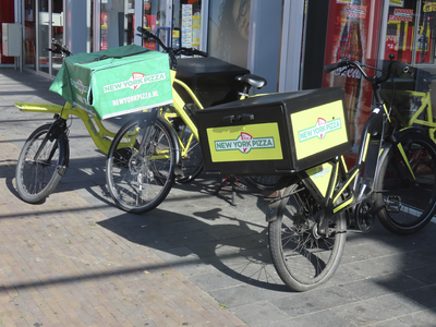 902478 Afbeelding van bezorgfietsen van New York Pizza geparkeerd voor het restaurant in winkelcentrum Mereveldplein te ...